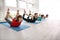 Group of sporty people practicing yoga indoors