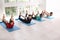 Group of sporty people practicing yoga indoors