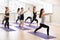 Group of sporty people practicing yoga with instructor, Warrior