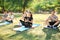 Group of sporty people practicing yoga in park