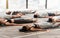 Group of sporty people relaxing during yoga lesson, lying in Corpse pose