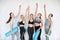 Group sporty women rejoice raising their hands up at gym. Team, friendship and helthy lifestyle