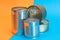 A Group of Stacked Tin Cans with Blank Edges on Split Blue and Orange Background