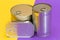 A Group of Stacked Tin Cans with Blank Edges on Split Yellow and Violet Background