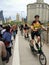 Group of standing elliptical bicyclists riding on a crowded Brooklyn Bridge. May 2018.