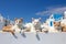 Group of stray cats on white building with blue sky in background