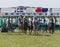 Group of striding jockeys after the start riding gallop arabian