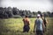 Group of strong male hunters going through rural field with tall grass during hunting season