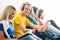 Group of students on a break reading books and using smartphones