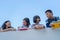 Group of students laugh happy standing together over wall walkway balckground bule sky