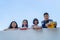 Group of students laugh happy standing together over wall walkway balckground bule sky