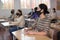 Group of students in protective mask listening attentively to teacher explaining material in the classroom