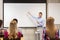 Group of students and smiling teacher with notepad