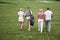 Group of stylish friends on the golf course learn to play a new game. The team is going to rest after the match