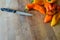 Group of sweet organic pointed peppers on a wooden cutting board with a kitchen knife