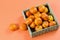 Group of tangerines in the straw ecological box on the orange background. Eco zero waste, no plastic, healthy food concept