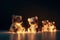 Group of teddy bears covered in glowing lights , in a christmas scene