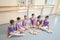 Group of teen ballerinas sitting on the floor.