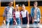 group of teen happy scholars looking at camera while standing in front of