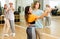 Group of teenage boys and girls training slow foxtrot movements in dance studio