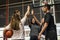 Group of teenage friends on a basketball court giving each other a high five