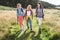 Group Of Teenage Girls Hiking In Countryside With Dog