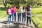 Group of teenage Latina student friends with their backpacks and notebooks reviewing their homework outdoors