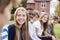 Group Of Teenage Students Sitting Outside School Buildings