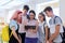 Group of teenage students and young female teacher with digital tablet in classroom