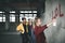 Group of teenagers girl gang indoors in abandoned building, using spray paint on wall.