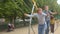 Group teenagers ride swing city park They swing, hold the chain their hands