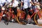 A group of teenagers using bicycles of the same type are gathering.