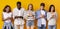 Group of teenagers using mobile phones over yellow background