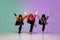 Group of teens, boys and girls dancing hip-hop in stylish clothes on gradient studio background in neon light.