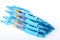 Group of ten blue plastic gel pens on a white background