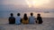 Group of Thai people, Asian friends, clanging bottles of beer together and celebrating on holiday in party at the beach or sea in