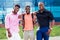 A group of three African Americans male friends in stylish clothes stand against the background of the blue windows of