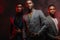 A group of three black men in stylish suits posing  in studio