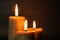 Group of three brown burning candles on a black background close-up. Concept of comfort,romance,mystic,occultism,religion,a symbol