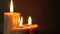 Group of three brown burning candles on a black background close-up. Concept of comfort,romance,mystic,occultism,religion,a symbol