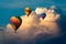 Group of three colorful balloons ascending past a massive storm cloud
