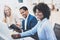 Group of three coworkers working together on business project in modern office.Young attractive african woman smiling, teamwork co