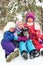 Group of three kids girls sitting in snow together