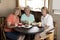 Group of three lovely middle age senior mature women girlfriends meeting for coffee and tea with cakes at coffee shop sharing time