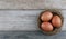 Group three natural chicken eggs from farm products in bird nest on vintage wooden background. Advertising image Easter or food