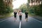 A group of three people athletes one girl and two men run on an asphalt road in a pine forest