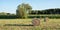 Group of three round bales of hay harvested in a field.