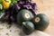 A group of three round green and yellow zucchinis on a wooden background. A bunch of fresh, raw parsley and basil.