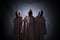 Group of three scary figures in hooded cloaks