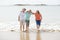 Group of three senior mature retired women on their 60s having fun enjoying together happy walking on the beach smiling playful